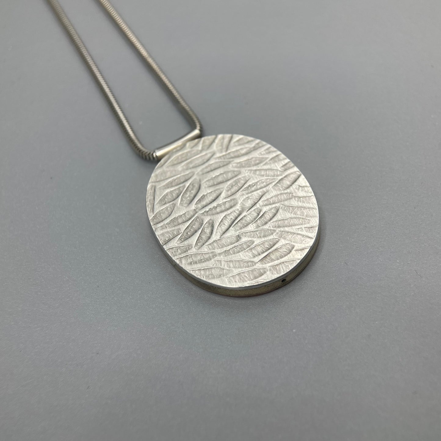 Papermetal Embossed Petals Reversible Oval Pendant