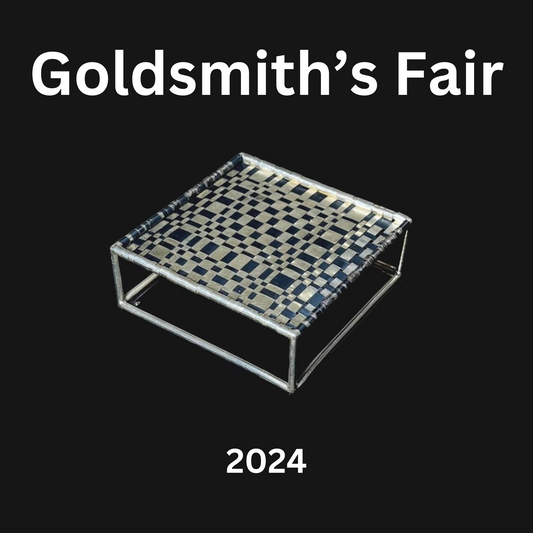 Poster reading 'Goldsmith's Fair' with an niobium wall-hanging in the centre