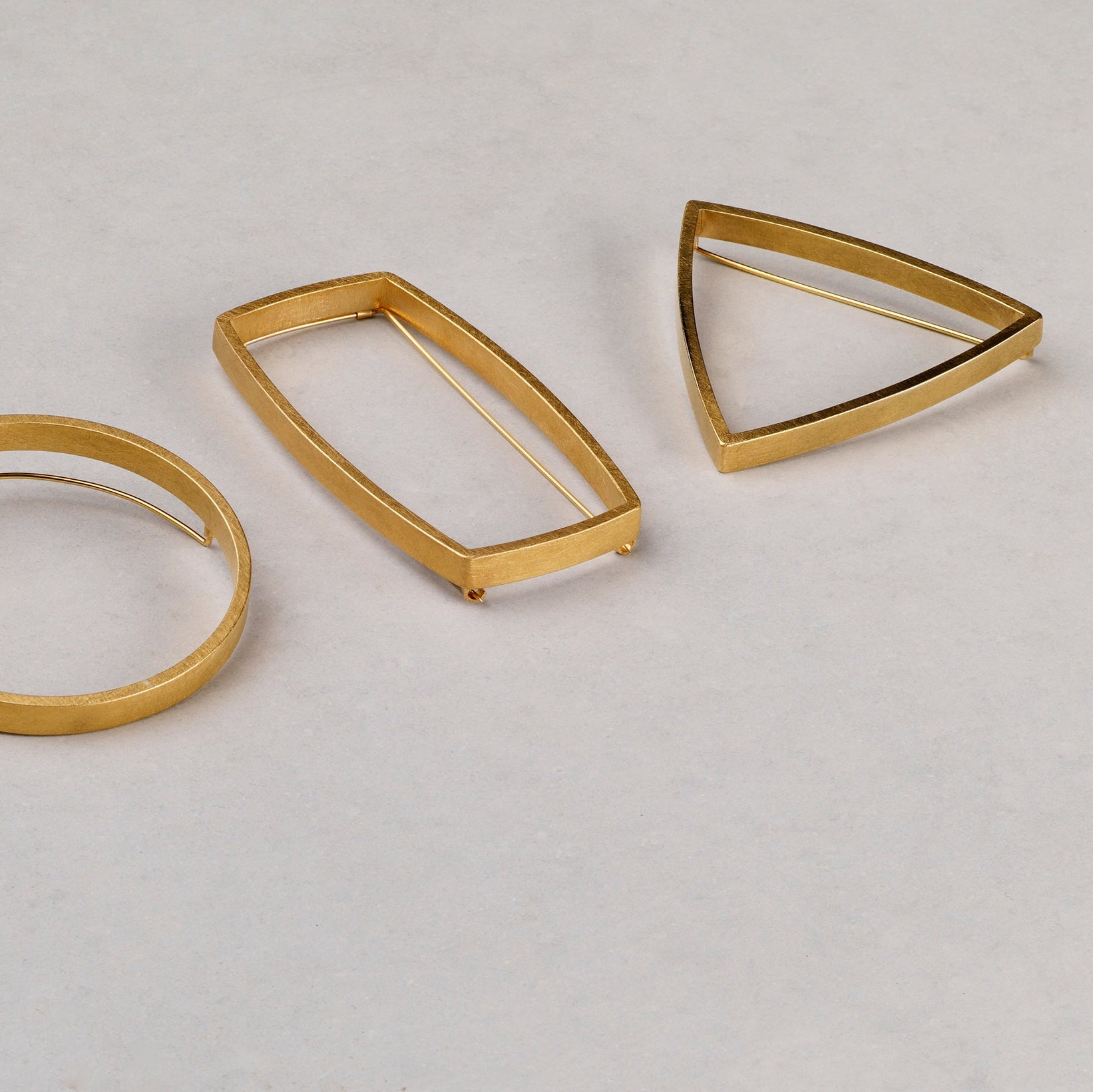 Set of gold metal rings on a light gray background