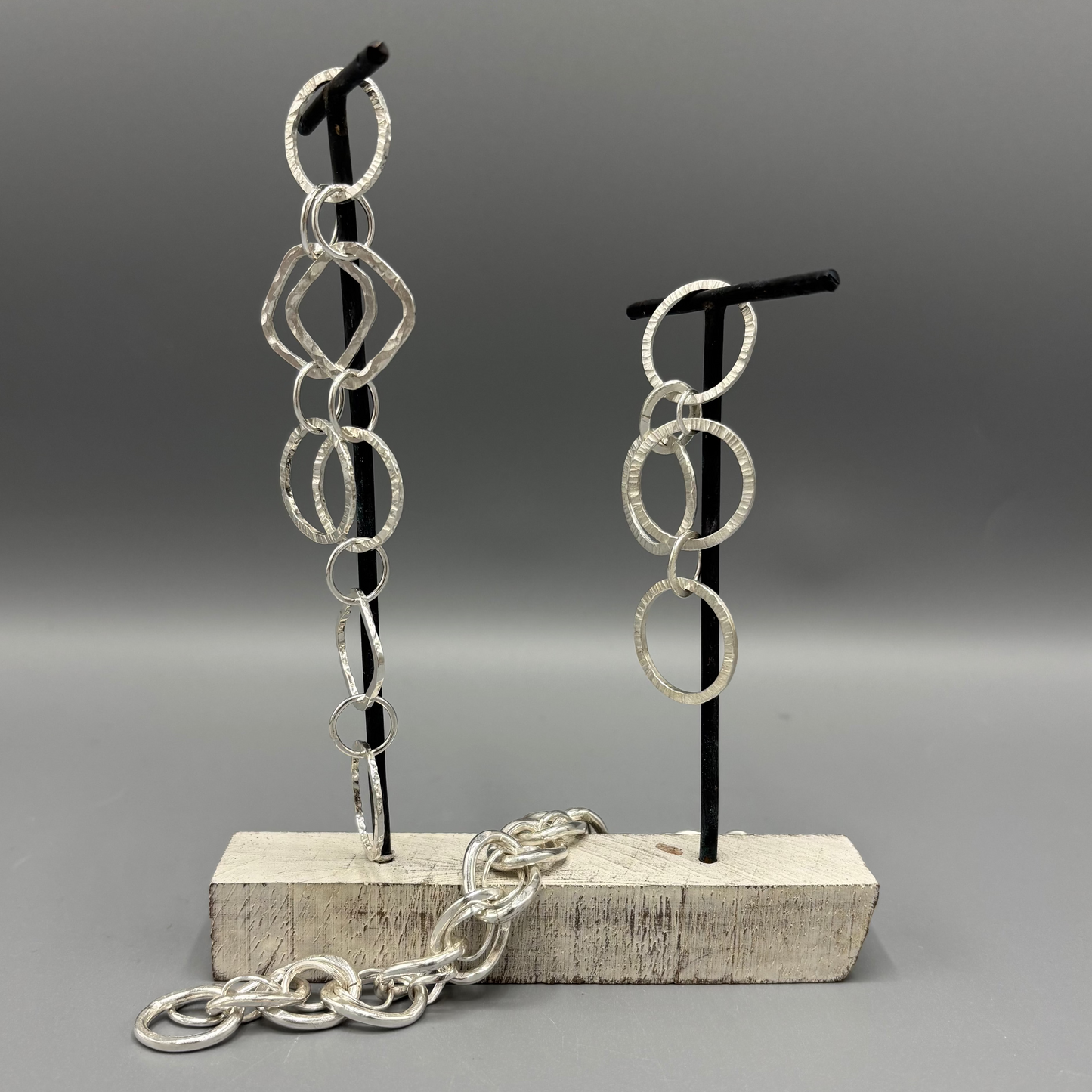 Silver chain earrings on a gray background