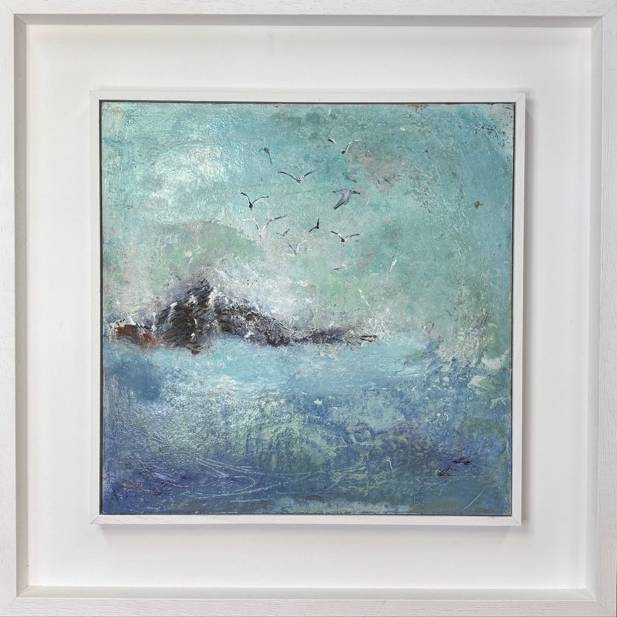 An abstract landscape painting of a sea wave and seagulls, presented in a wide white frame. The painting features textured brushstrokes in shades of teal, blue, and white, with a dark, near-black wave crest and several small birds flying above.